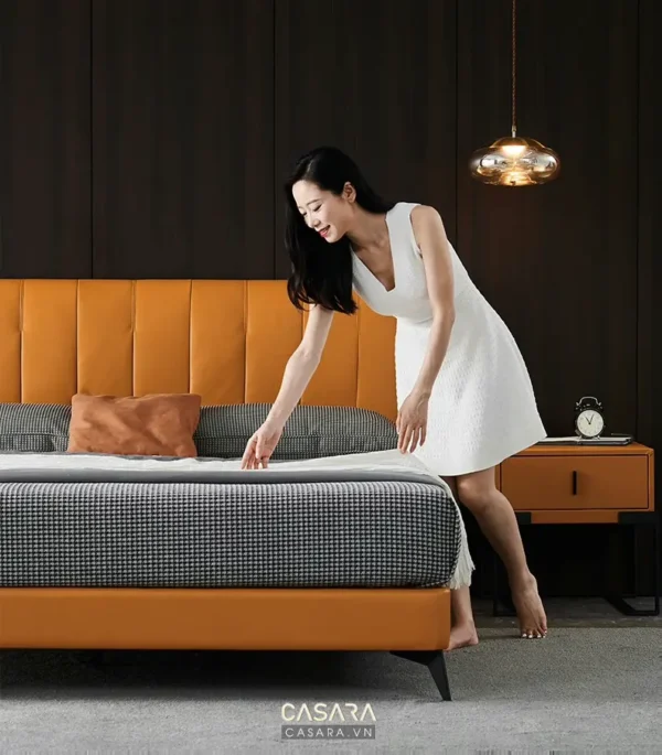 Cô gái trẻ trung chỉnh chăn trên giường ngủ hiện đại.