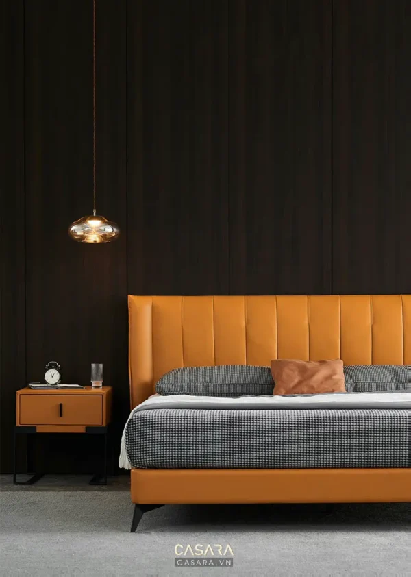 Phòng ngủ hiện đại với giường màu cam nổi bật và đèn thả trần.
