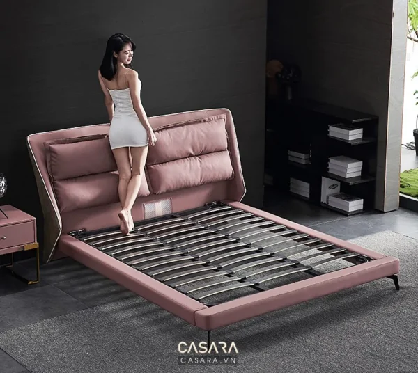 Giường ngủ màu hồng pastel hiện đại, sang trọng trong phòng tối.