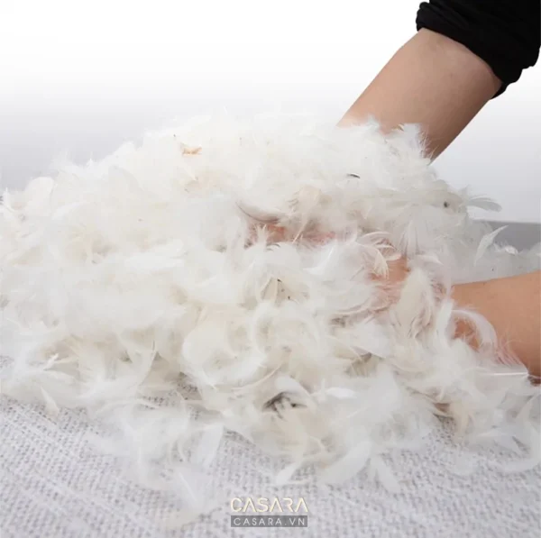 Bàn tay đang nắm chặt một nắm lớn sợi bông trắng mềm mại.