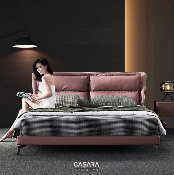 Người phụ nữ đọc sách thư giãn trên giường ngủ hiện đại màu hồng.