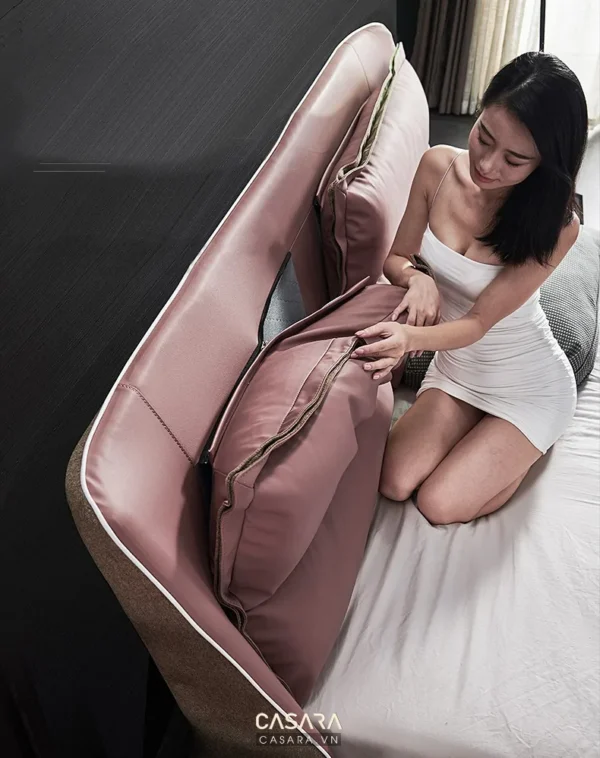 Người phụ nữ thư giãn trên chiếc ghế sofa màu hồng nhạt.