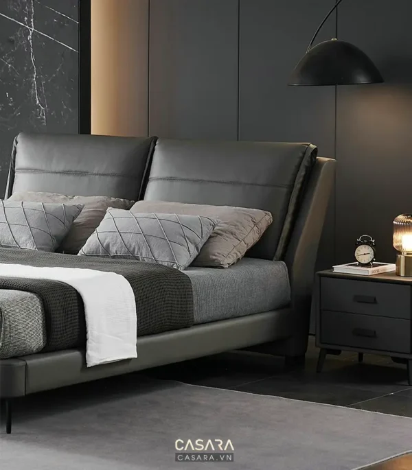 Phòng ngủ sang trọng với giường da đầu cao và nội thất tối giản.