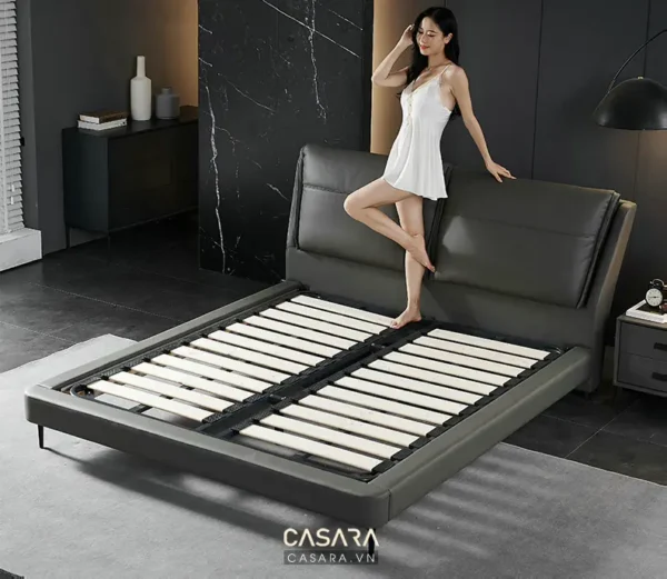 Người mẫu tạo dáng bên chiếc giường ngủ hiện đại, sang trọng.