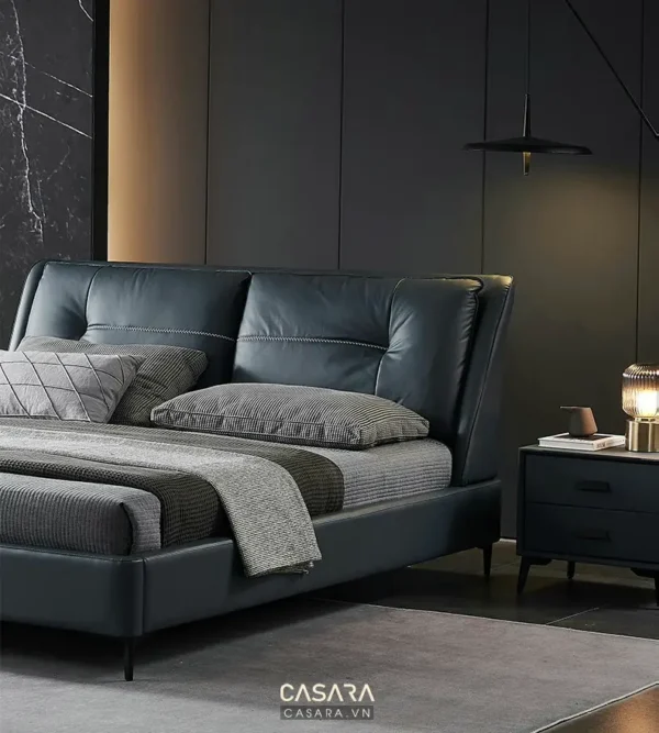 Phòng ngủ sang trọng với giường da màu xanh than và nội thất tối giản.