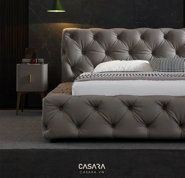 Giường ngủ bọc da sang trọng, hiện đại trong phòng tối màu.