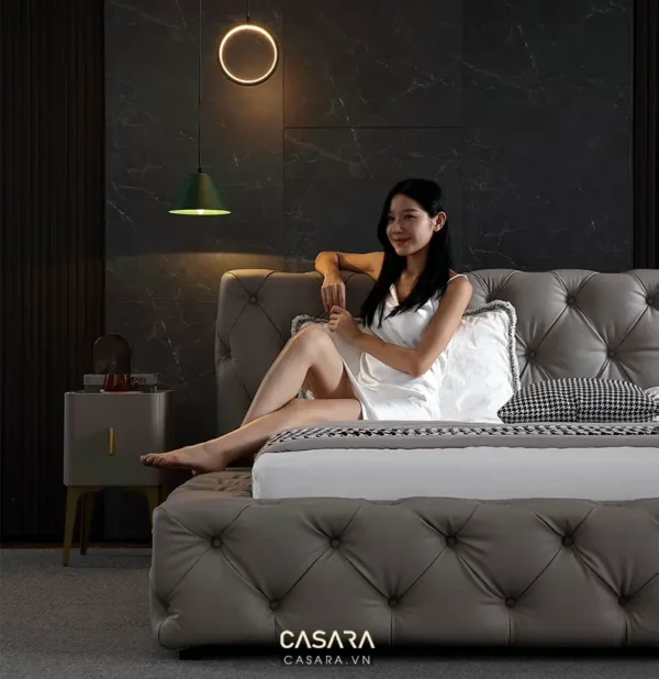 Cô gái trẻ thư giãn trên giường trong phòng ngủ hiện đại, sang trọng.