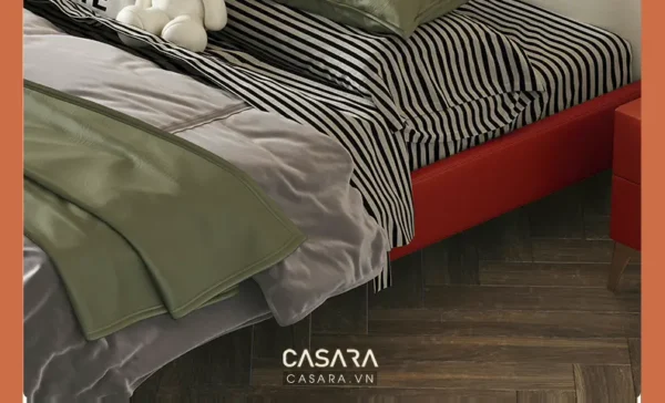 Giường ngủ hiện đại với bộ chăn ga gối màu xanh lá và đen trắng.