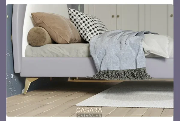 Góc giường ấm cúng với chăn, gối và thảm trải sàn.