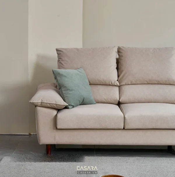Ghế sofa màu hồng nhạt với gối xanh.
