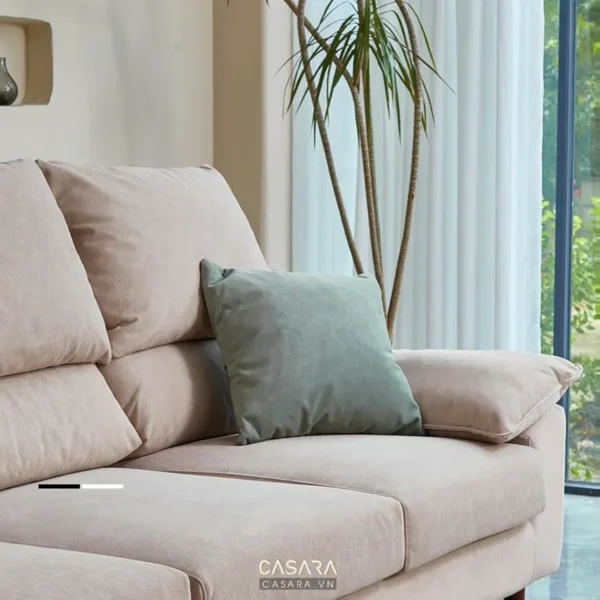 Góc phòng khách với ghế sofa và gối xanh.