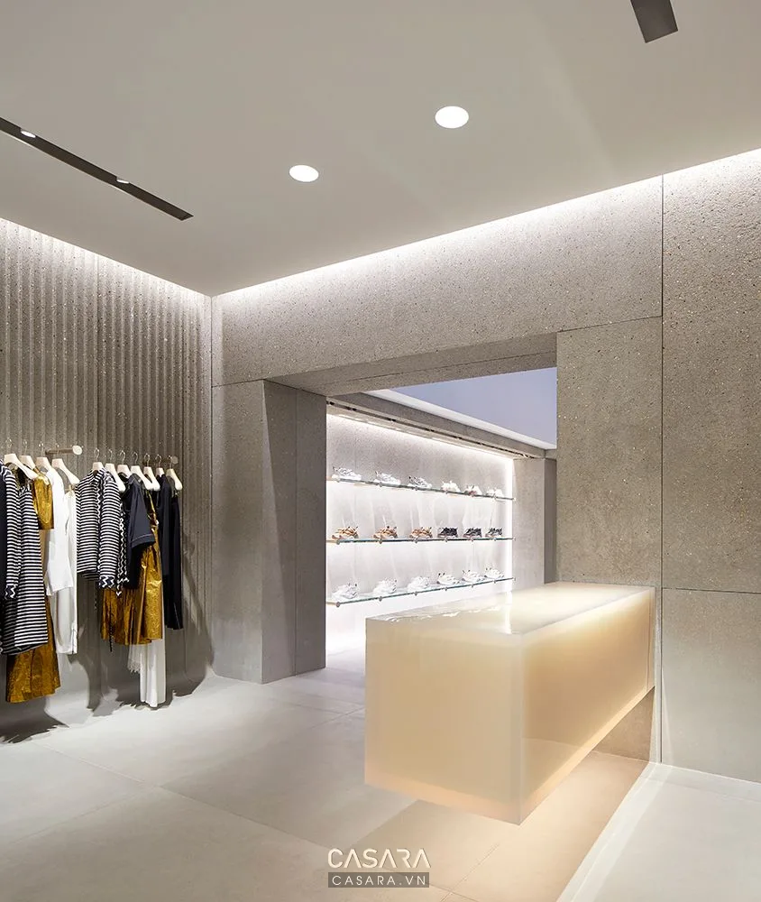 Toàn cảnh showroom rộng với lối đi thoáng, khu trưng bày sản phẩm, bàn tư vấn sang trọng và ánh sáng nhiều lớp.