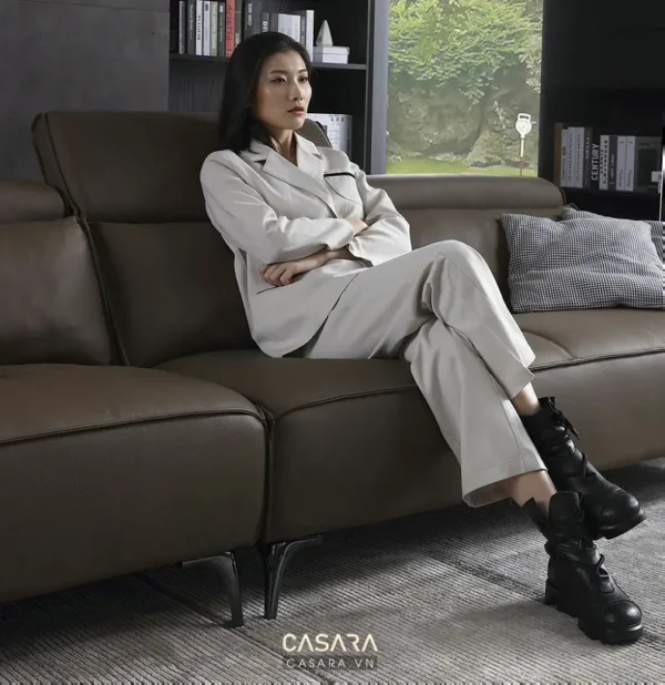 Cô gái trẻ thư giãn trên chiếc sofa da hiện đại sang trọng.