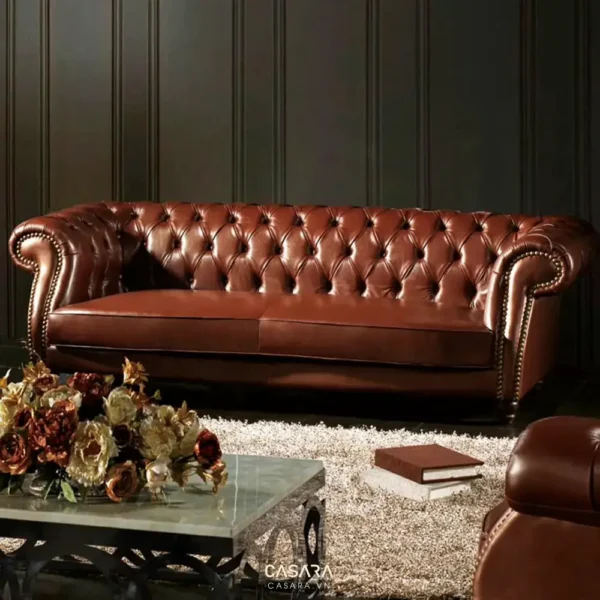 Ghế sofa da nâu cổ điển với họa tiết nút bấm, đặt trong phòng khách sang trọng.