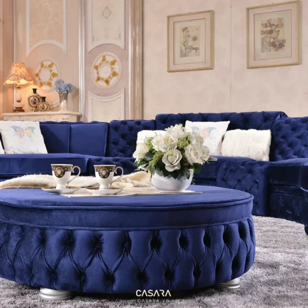 Phòng khách sang trọng với sofa xanh dương và bàn tròn cùng hoa trắng