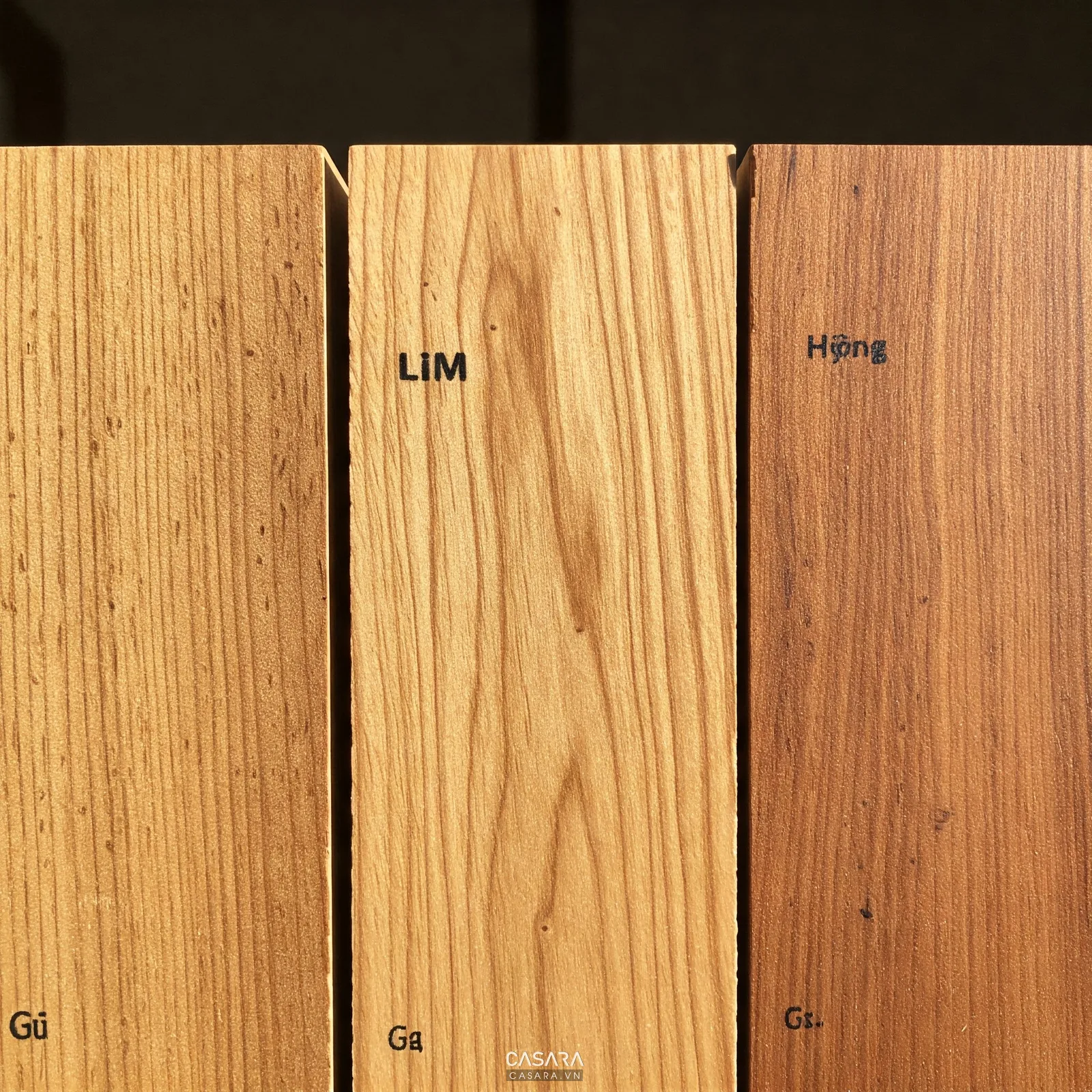 Mẫu vân gỗ gõ đỏ và gỗ lim đặt cạnh nhau để so sánh màu sắc, vân gỗ và độ ấm của vật liệu phòng thờ.