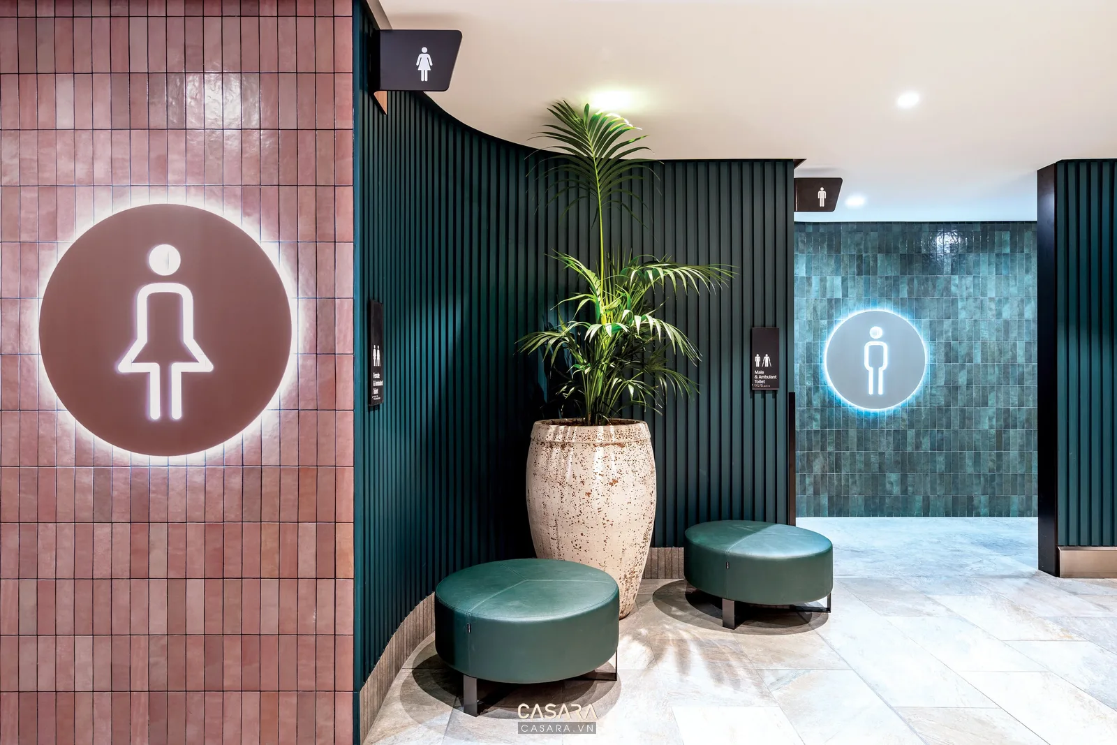 Khu vệ sinh trong quán bar lounge với vật liệu dễ lau, ánh sáng rõ và ghế chờ cho khách.