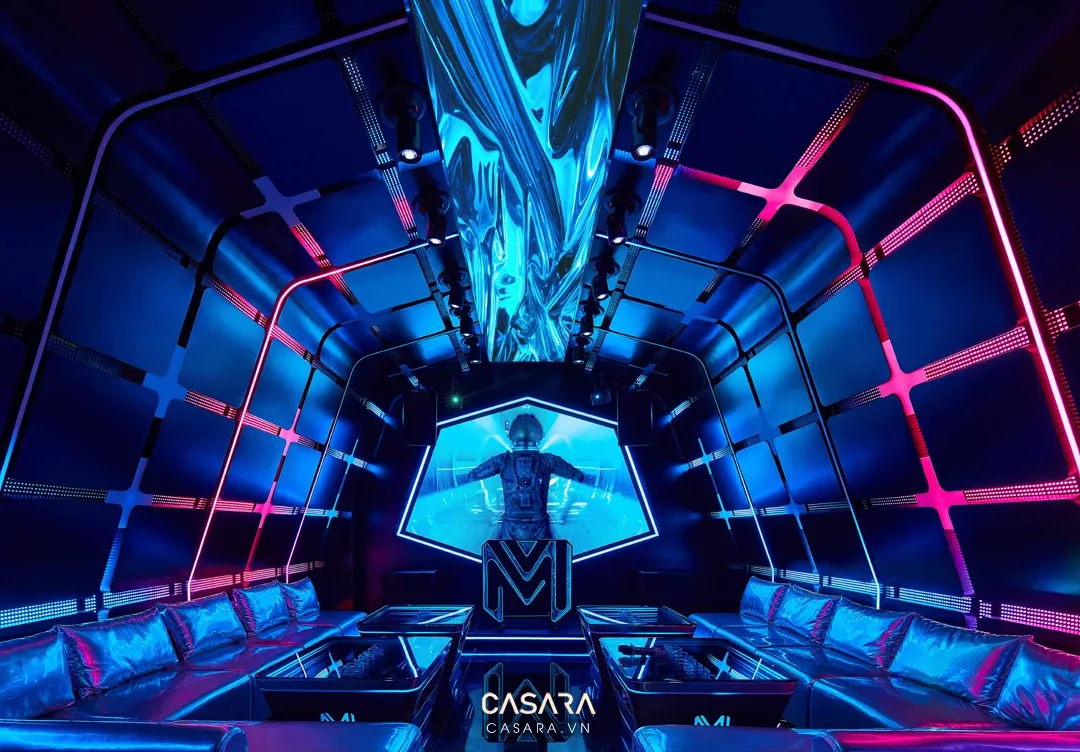 Thiết kế quán bar karaoke phong cách futuristic với ánh sáng xanh hồng, trần kỹ thuật và điểm nhấn sân khấu.