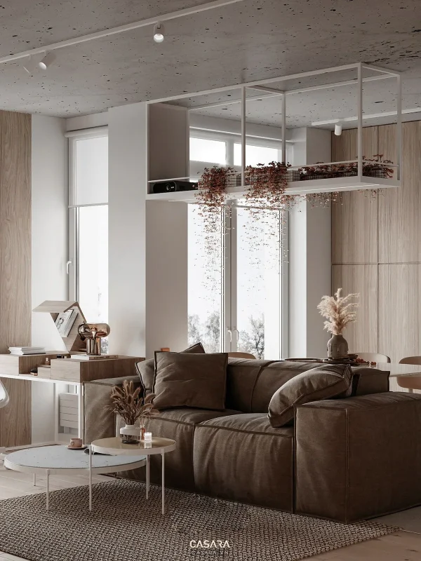 Phòng khách sáng tự nhiên với sofa nâu, bàn trà tròn và gác lửng phía trên