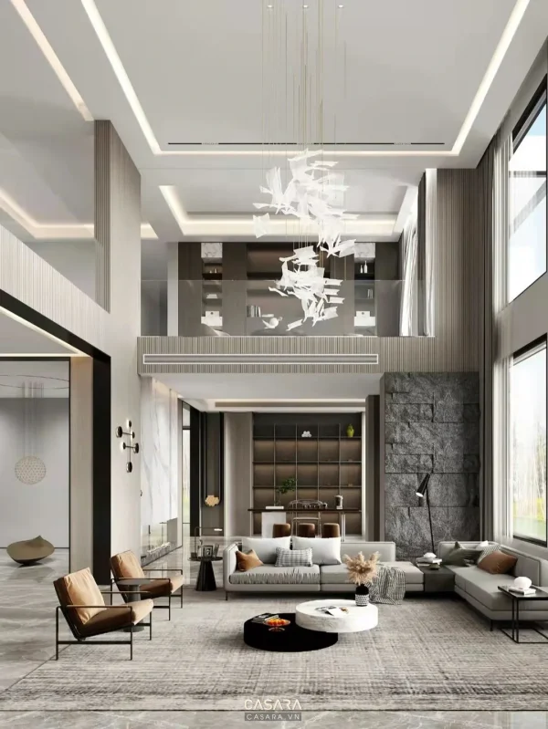 Phòng khách thông tầng với sofa chữ L, bàn trà tròn, đèn thả và cửa kính lớn