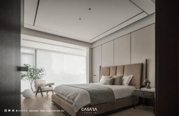 Phòng ngủ luxury gỗ tự nhiên với giường lớn, vách đầu giường và ánh sáng dịu.