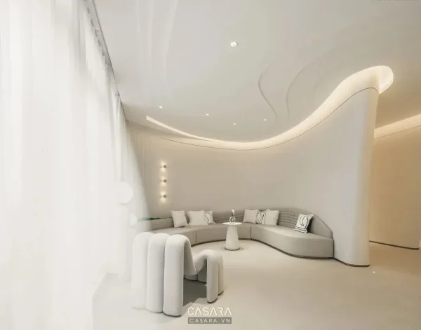 Phòng chờ salon tông trắng kem có sofa bo cong và rèm voan