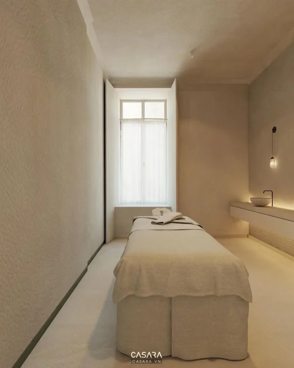Phòng spa nhỏ tối giản có giường trị liệu, ánh sáng dịu và bề mặt sạch dễ vận hành.
