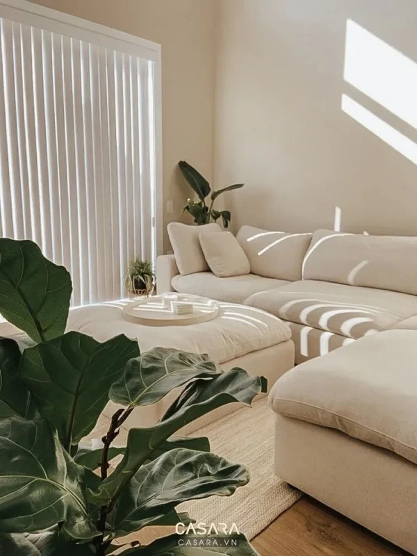 Sofa góc cạnh cây xanh và ánh sáng tự nhiên trong phòng khách nhà ống