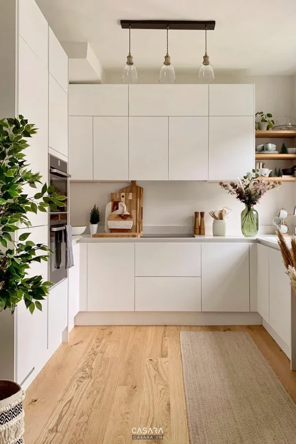 Tủ bếp trắng gỗ với kệ mở và sàn gỗ sáng cho chủ đề chung cư nhỏ Casara.