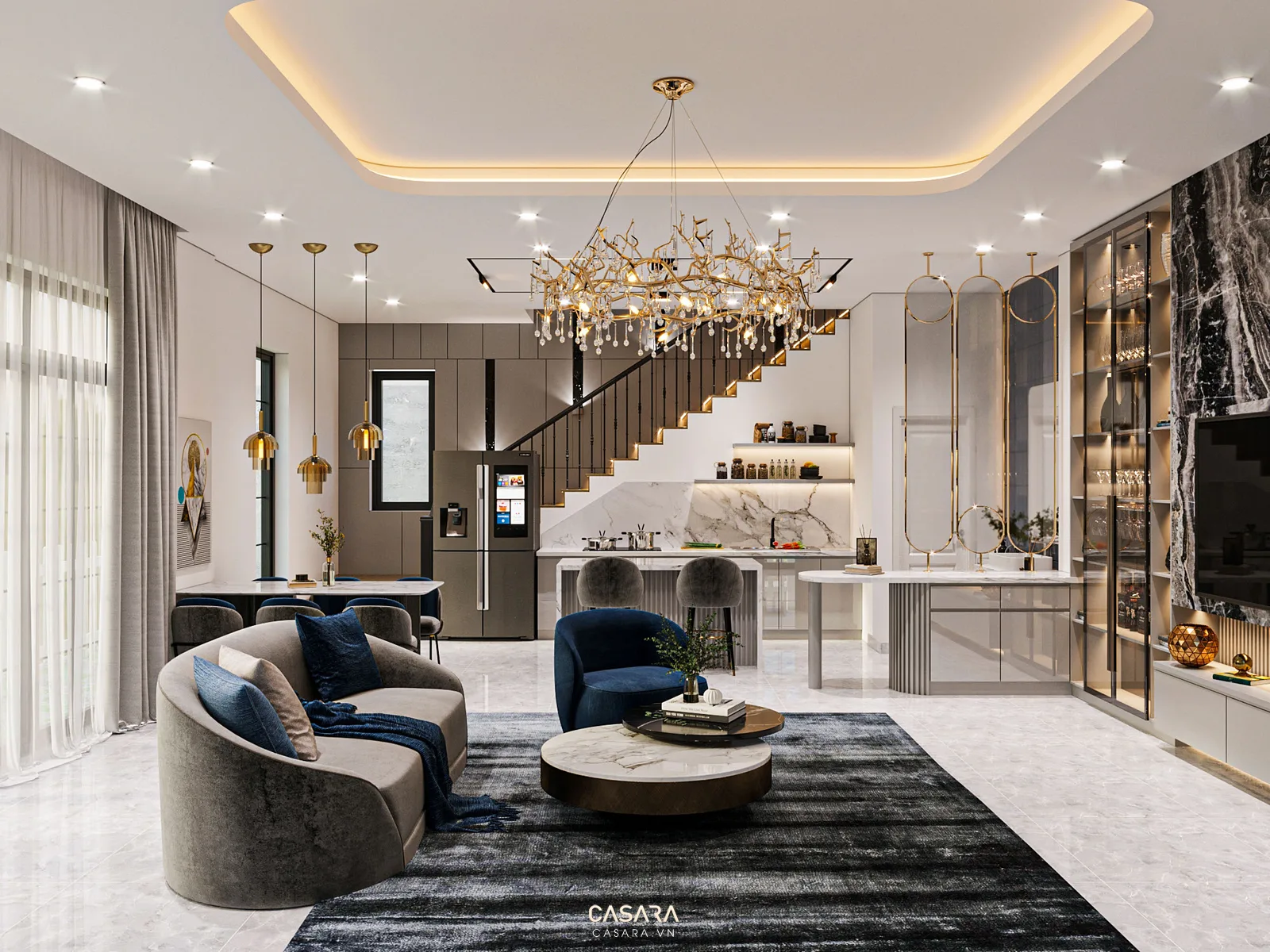 Phòng khách liền bếp với sofa cong, đèn chùm và cầu thang phía sau