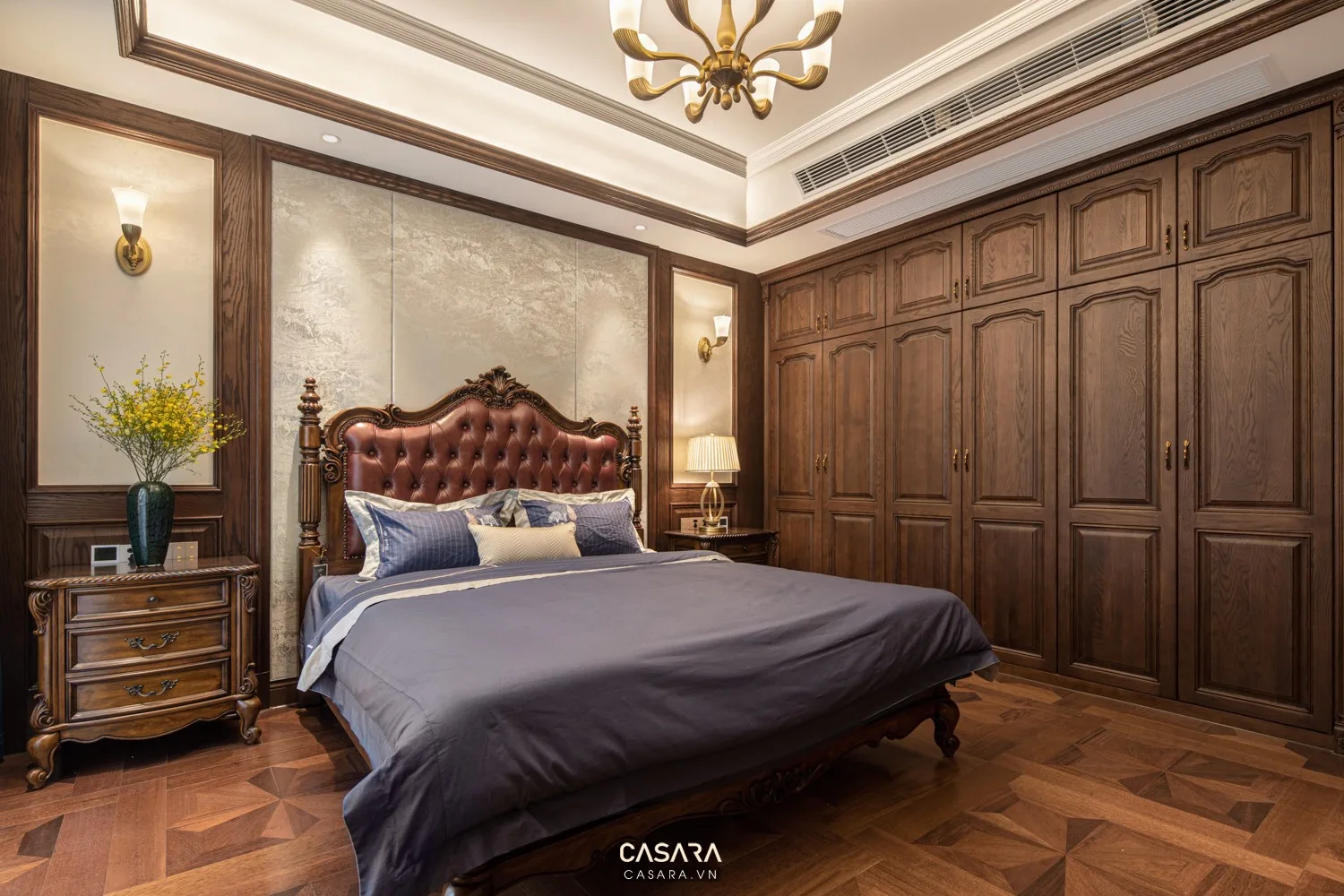 Tủ áo phòng ngủ phong cách nội thất đông dương với cánh gỗ veneer, chi tiết mây đan, tay nắm đồng, giường ngủ thấp, bàn trang điểm nhỏ và ánh sáng vàng ấm