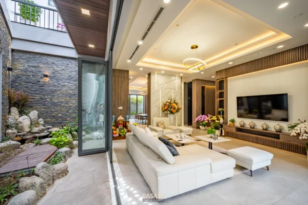 Phòng khách biệt thự sáng rộng với cửa kính lớn nhìn ra sân vườn
