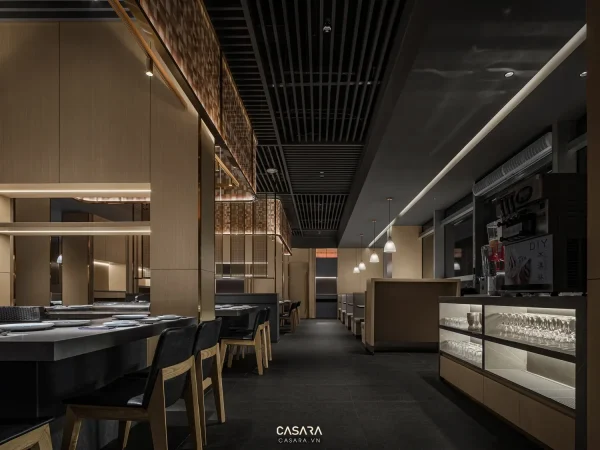 Nội thất nhà hàng hiện đại với quầy bar, bàn ghế gỗ và hệ đèn trần ấm