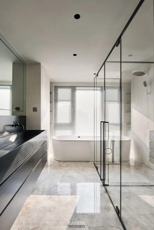 Ảnh phòng tắm ốp đá nâu có đèn hắt và vách kính do Casara tuyển chọn cho thư viện thiết kế nội thất.