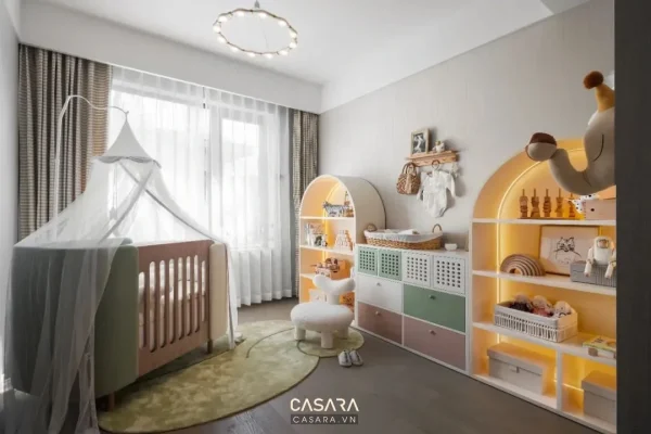 Ảnh góc chơi trẻ em màu hồng cam với nôi và tranh cầu vồng do Casara tuyển chọn cho thư viện thiết kế nội thất.