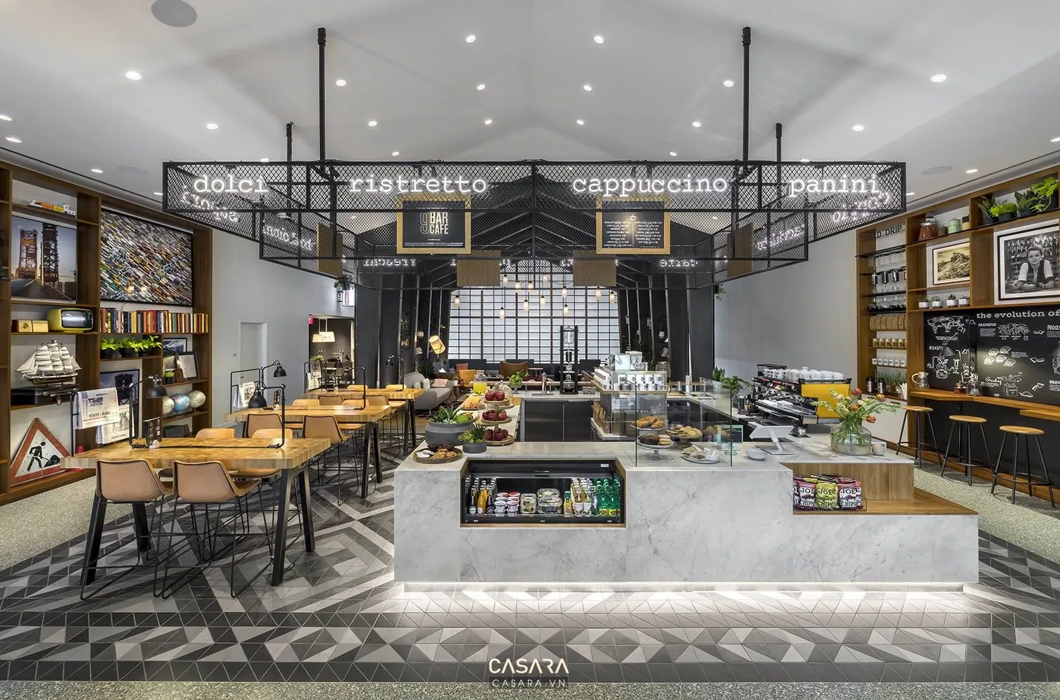Nội thất quán cafe với bàn ghế gỗ, đèn thả ánh sáng ấm và cây xanh