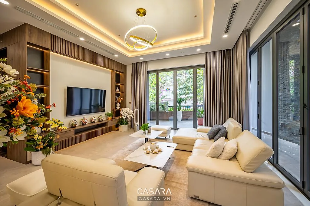 Mẫu nội thất nhà đẹp với decor phòng khách gồm thảm, rèm, tranh treo tường, cây xanh và sofa