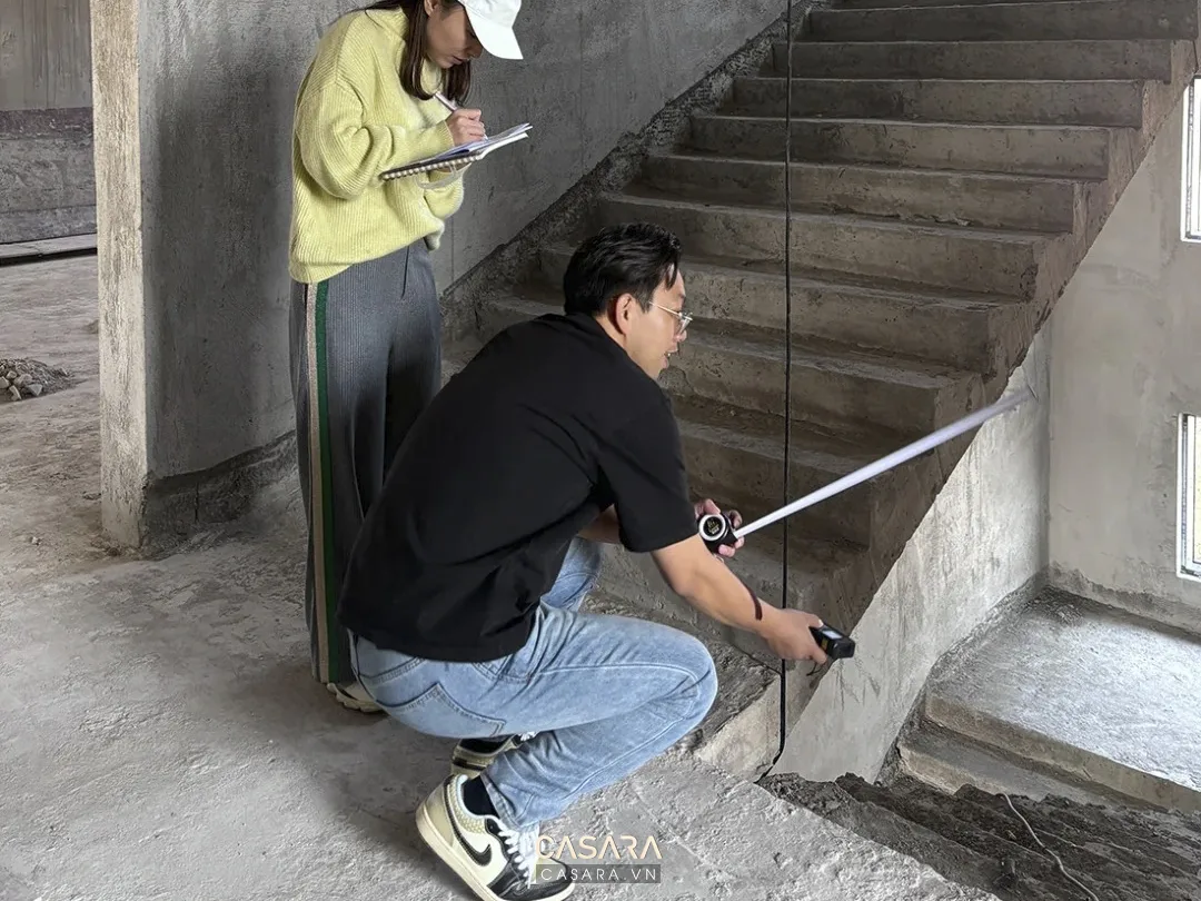 Nhân sự đo đạc khu vực cầu thang trong công trình thô