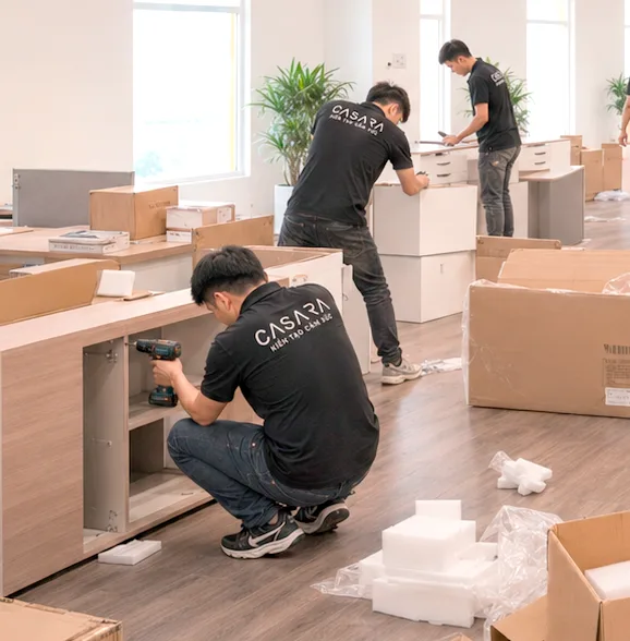Đội thi công đang lắp đặt bàn tủ trong văn phòng