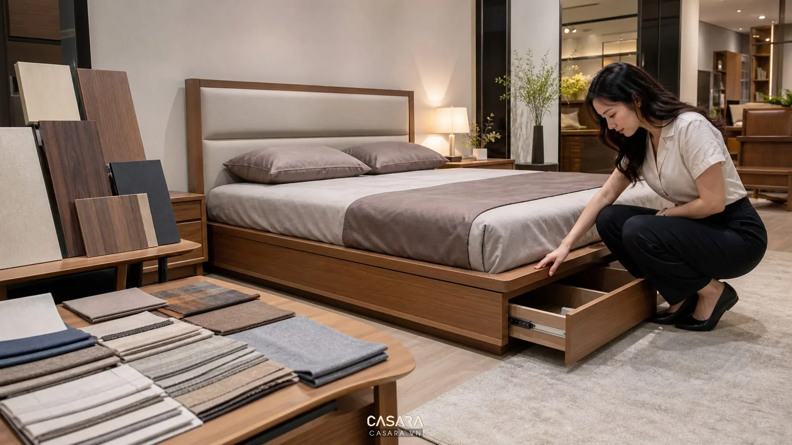người dùng kiểm tra mẫu giường thông minh trong showroom nội thất có hộc kéo mở bảng mẫu gỗ và vải cạnh giường