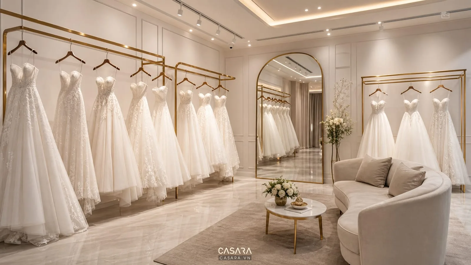 khu trưng bày váy cưới với áo cưới trắng, gương lớn và ghế sofa chờ