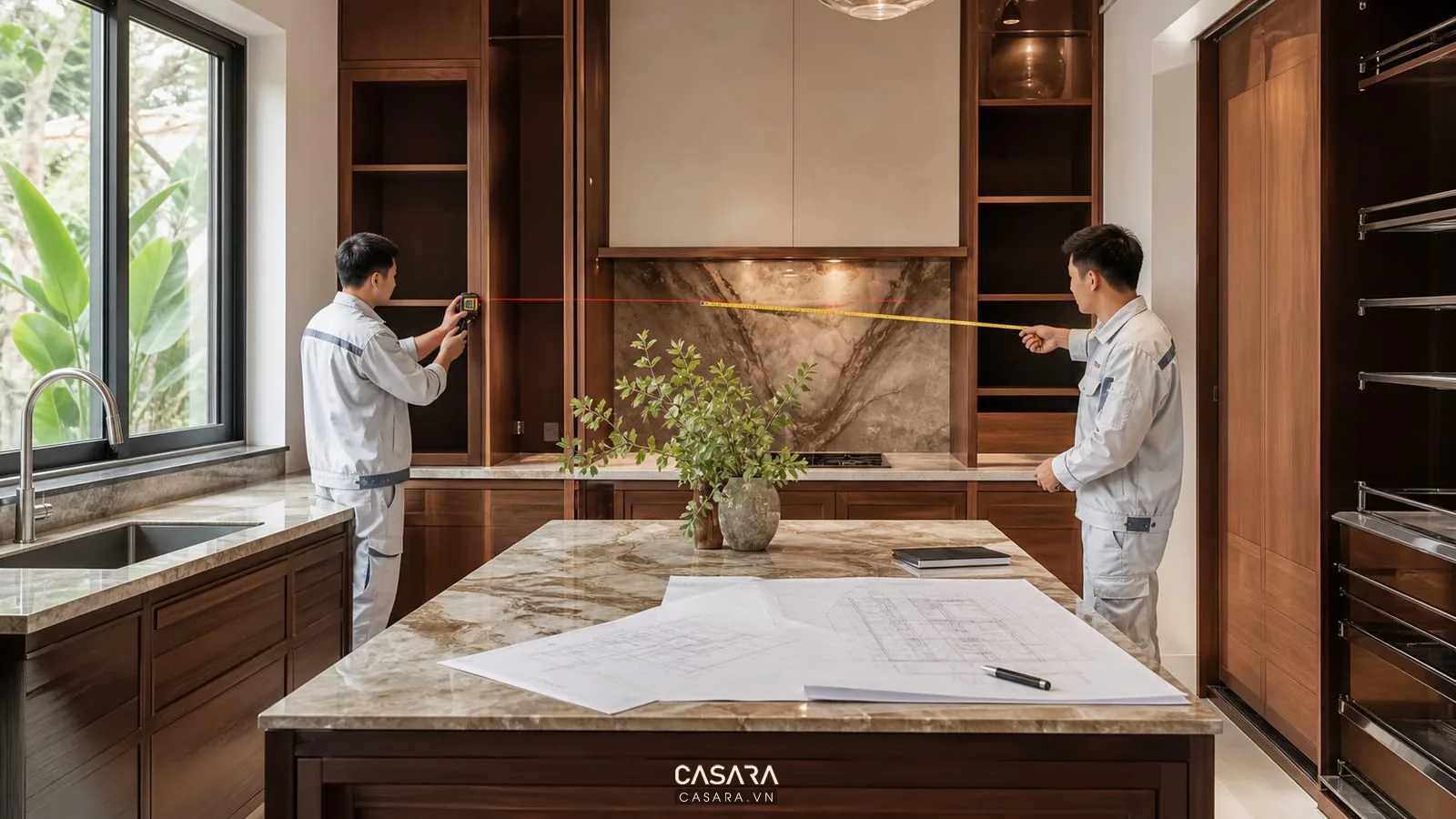 Đội thi công biệt thự đo đạc phòng bếp và kiểm tra bản vẽ kỹ thuật trước khi lắp đặt