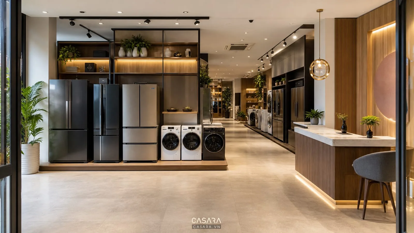 Khu sau cửa showroom đồ gia dụng có khoảng đệm rộng, tủ lạnh, máy giặt, quầy tư vấn lệch bên và lối đi chính rõ ràng.