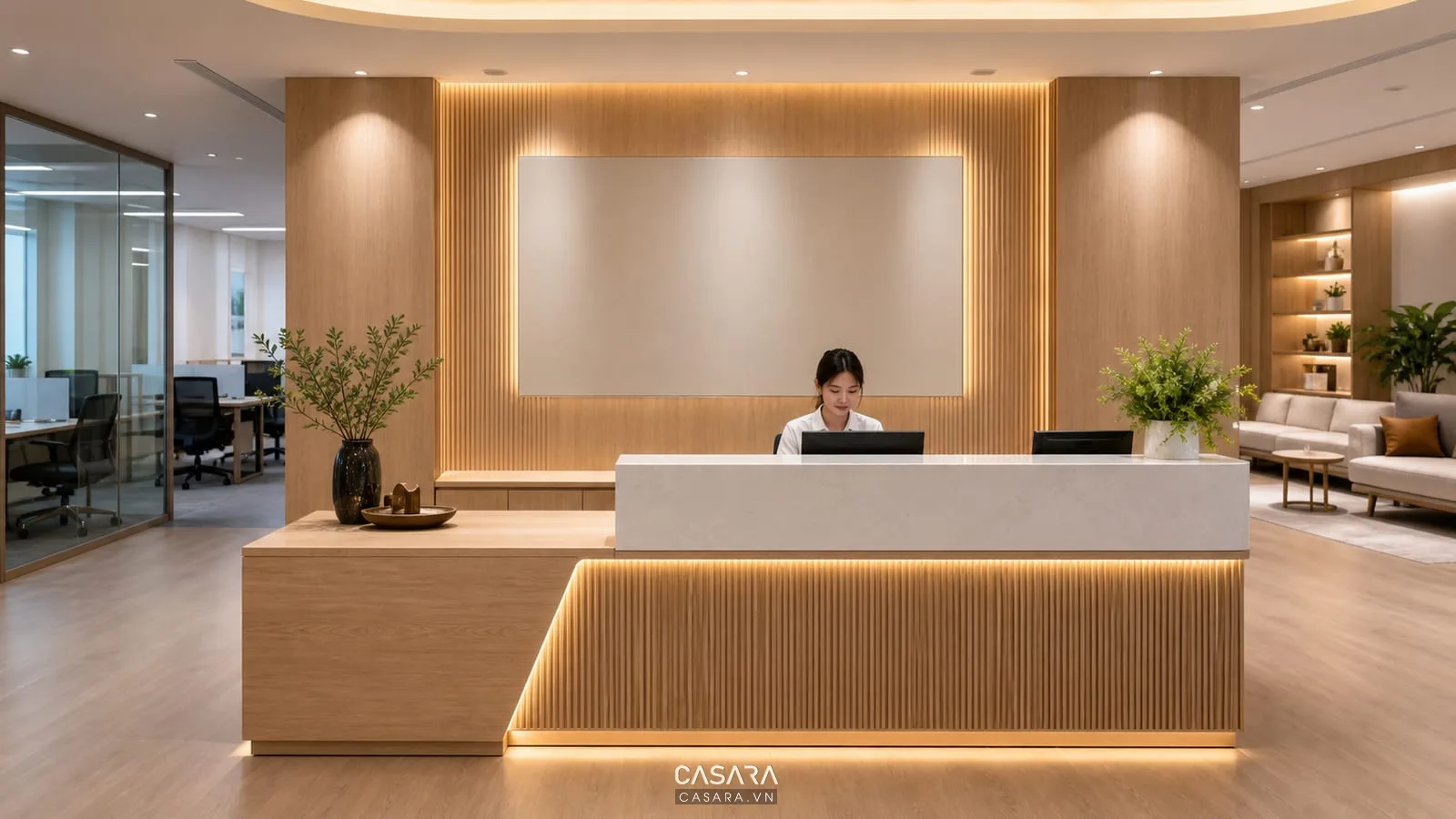 quầy lễ tân văn phòng có vách logo gỗ sáng và đèn hắt