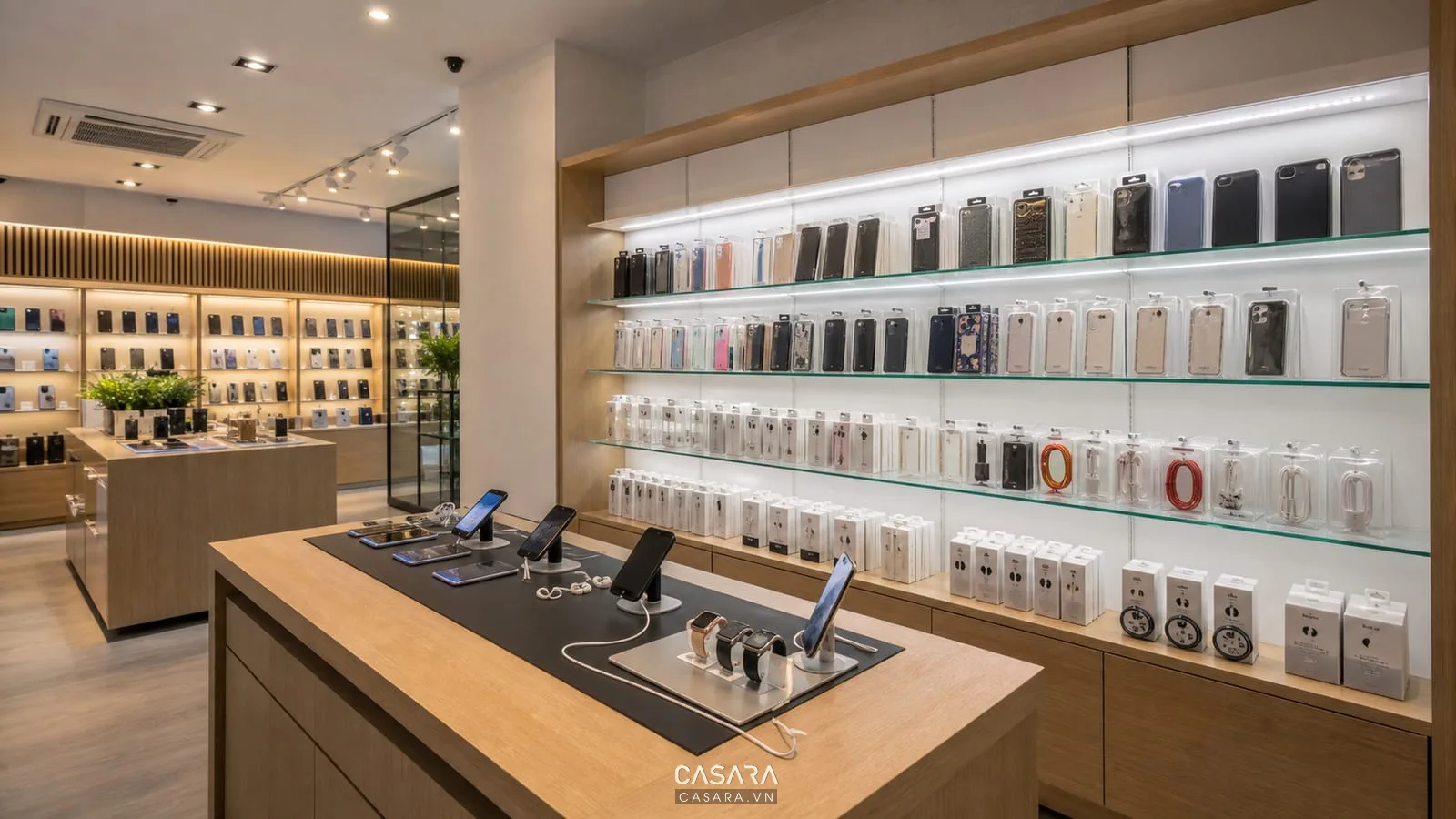 Khu phụ kiện showroom điện thoại có ốp lưng, sạc, cáp, tai nghe, kính cường lực trên kệ sáng và điện thoại mẫu để thử.