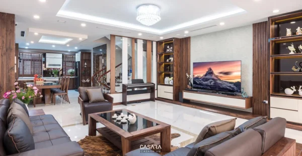 Phòng khách rộng với sofa da, bàn trà gỗ và kệ tivi đồng bộ