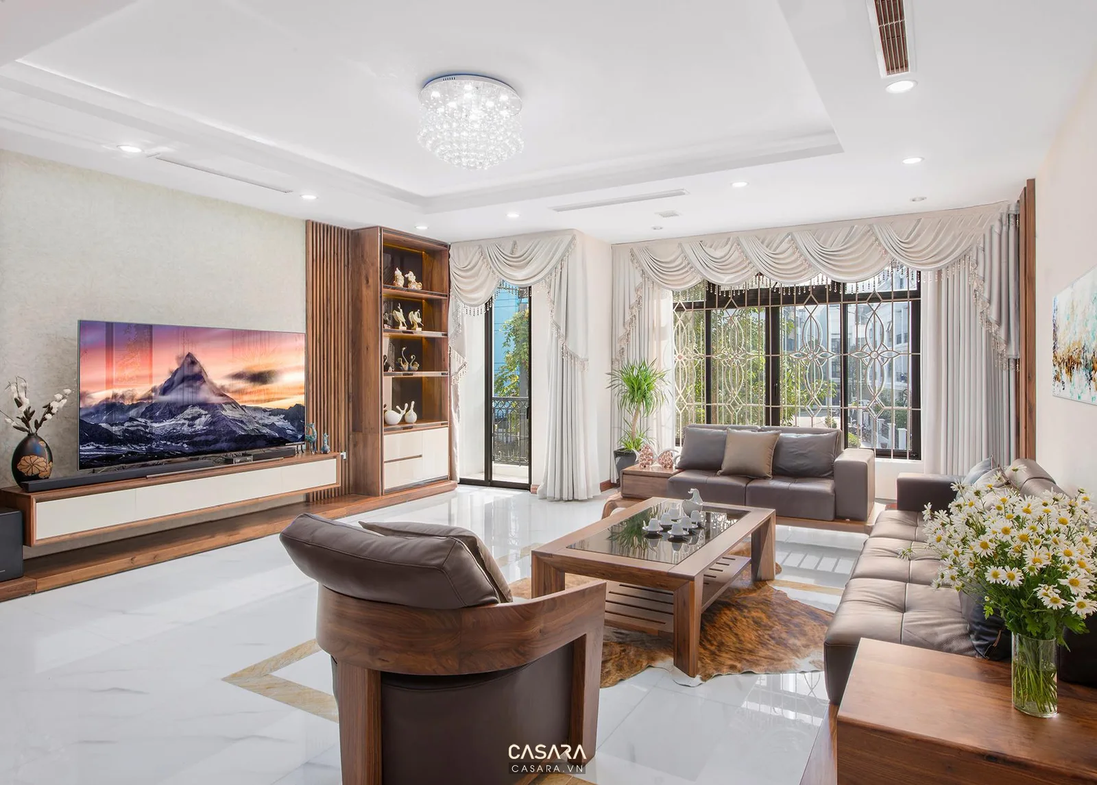 Phòng khách rộng sáng với sofa, bàn trà gỗ, kệ tivi và rèm trắng