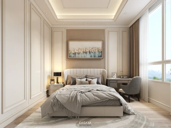 Phòng ngủ tông kem có giường bọc nệm, tủ âm tường và bàn làm việc cạnh cửa sổ