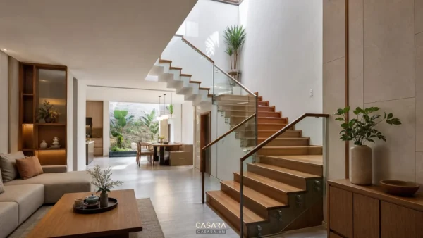 Cầu thang nhà đẹp với bậc gỗ, lan can kính và ánh sáng tự nhiên trong nhà phố