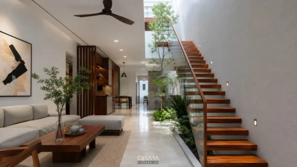 mẫu cầu thang dọc nhà ống bậc gỗ lan can kính trong phòng khách hiện đại
